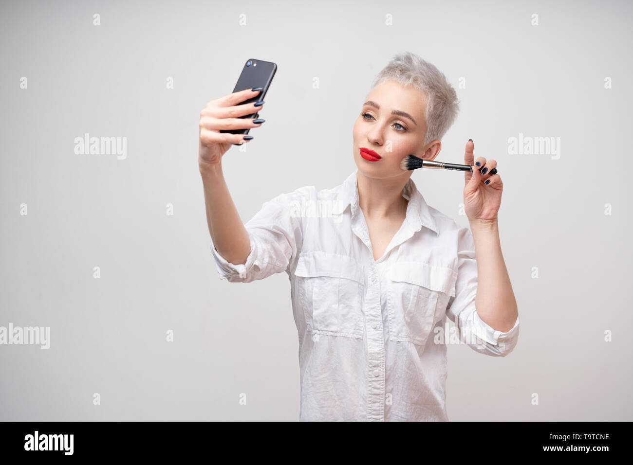 Studio Portrait Of Beautiful Trendy Girl With Short Hair Taking