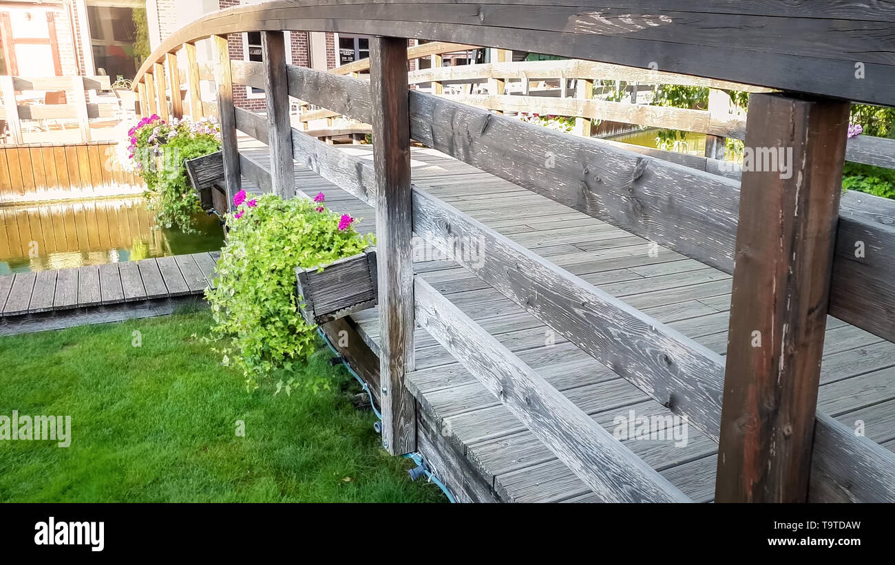 Closeup image of beautiful old wooden bridge with flowers growing in ...