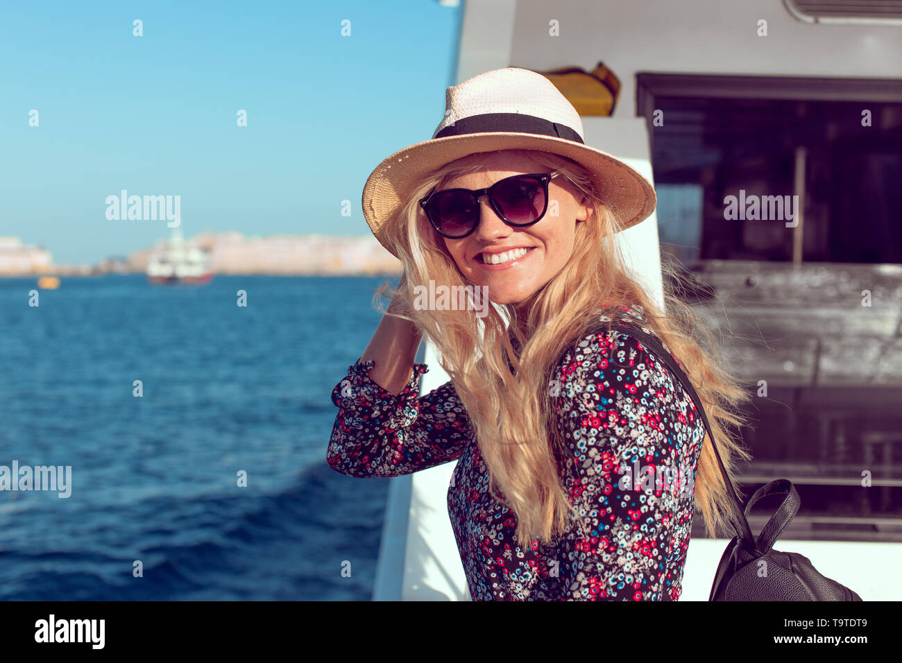 Happy blonde traveler woman toothy smile on cruise ship on Mediterranean sea Stock Photo