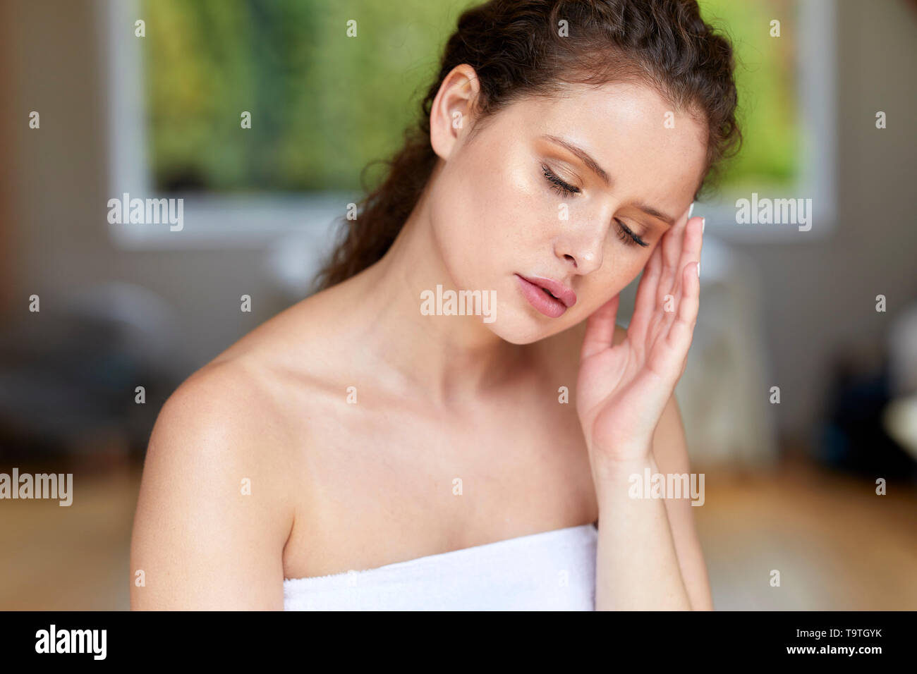 Woman sat with a headache Stock Photo