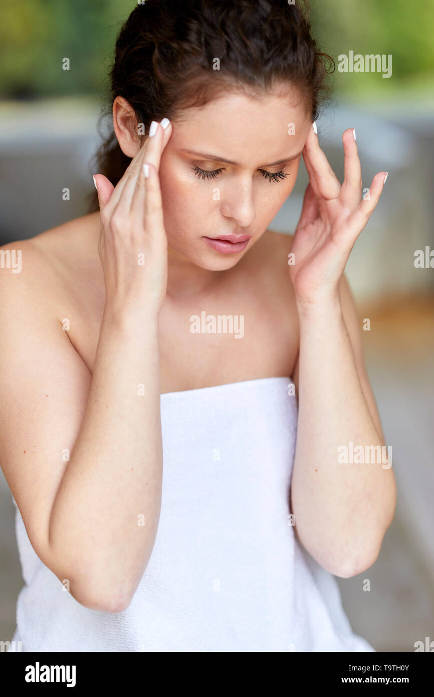 Woman sat with a headache Stock Photo