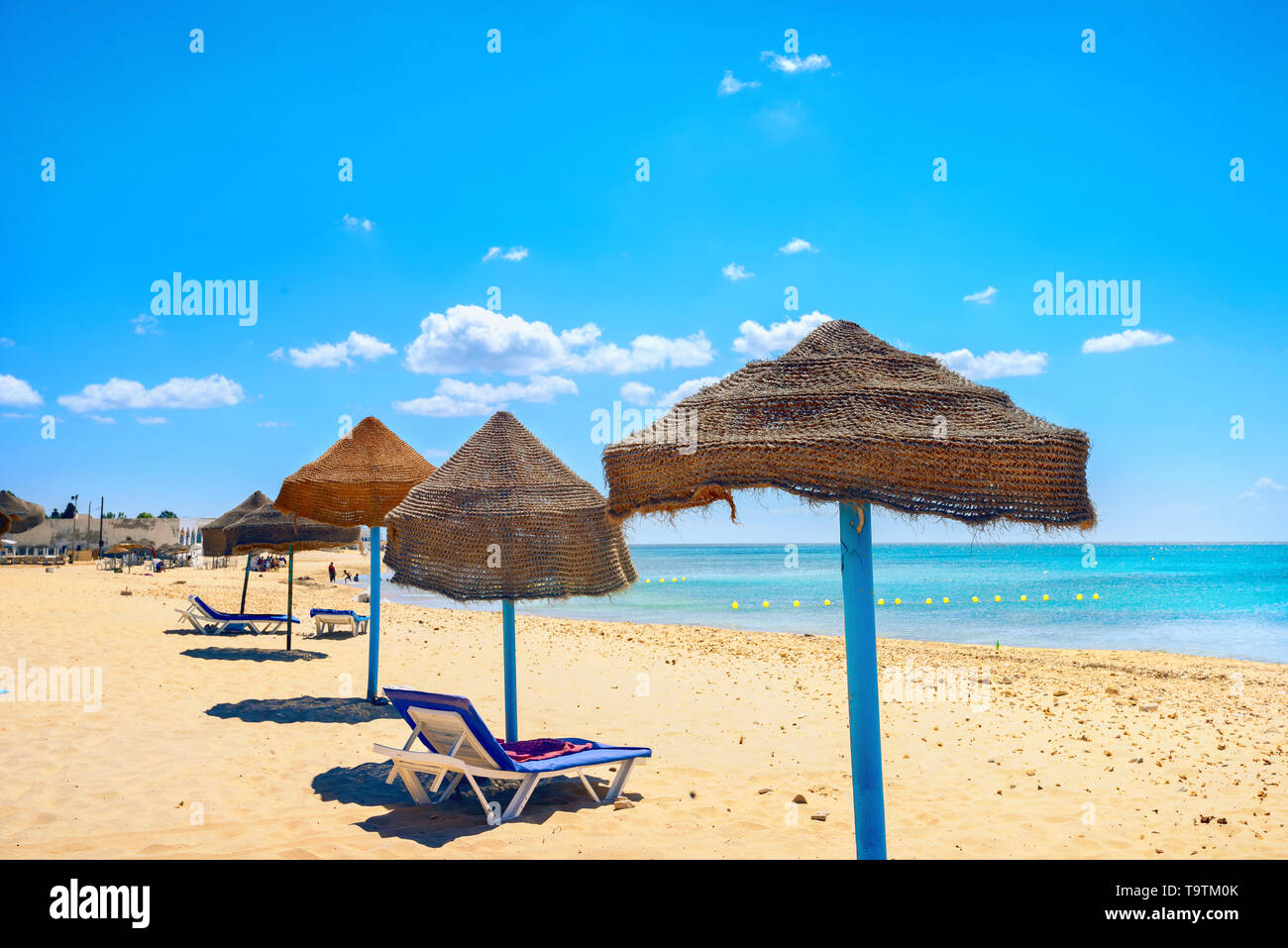 Landscape with sunshades on beach in resort town Nabeul. Tunisia, North Africa Stock Photo