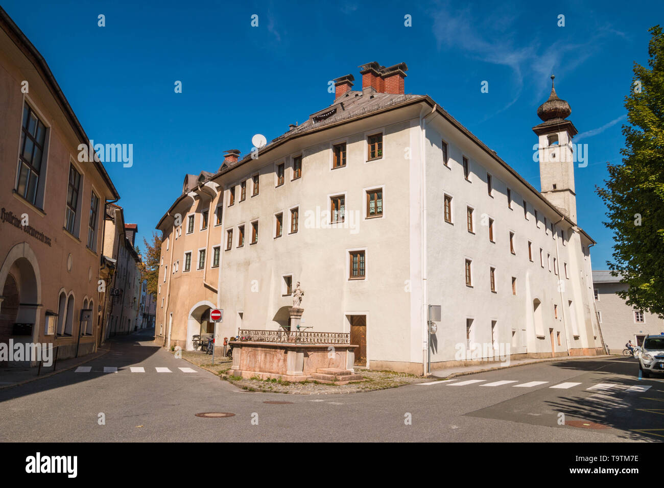 Hallein, Austria - September 12, 2018: Narrow streets of Hallein old town and hospital church Bürgerspitalkirche with onion dome. Stock Photo