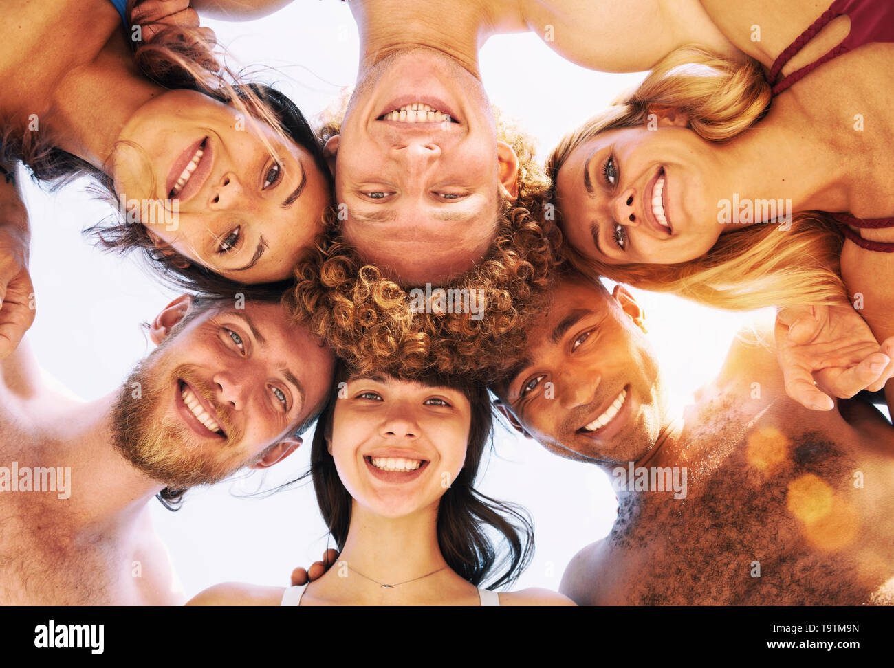 Happy group of friends in circle under the sun in the summertime Stock Photo