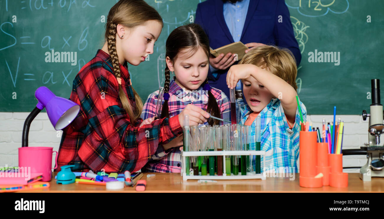 back to school. kids in lab coat learning chemistry in school laboratory. chemistry lab. making experiment in lab or chemical cabinet. happy children  Stock Photo