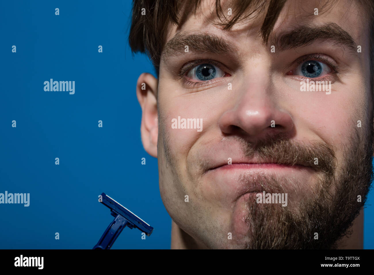 Man face half shaved and bearded with razor Stock Photo