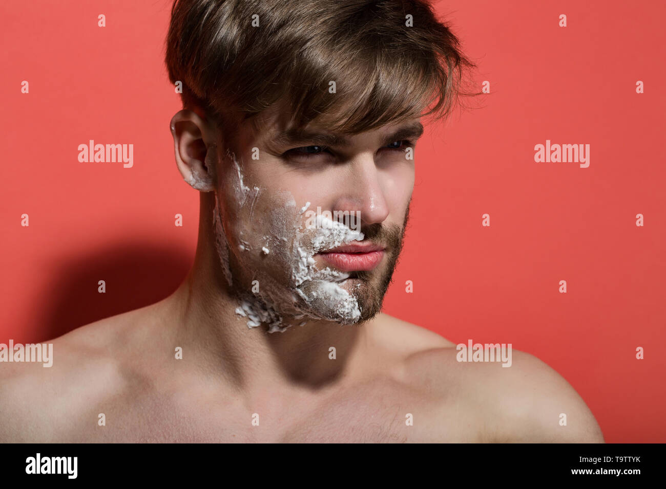 Man face half shaved and bearded with shaving cream Stock Photo