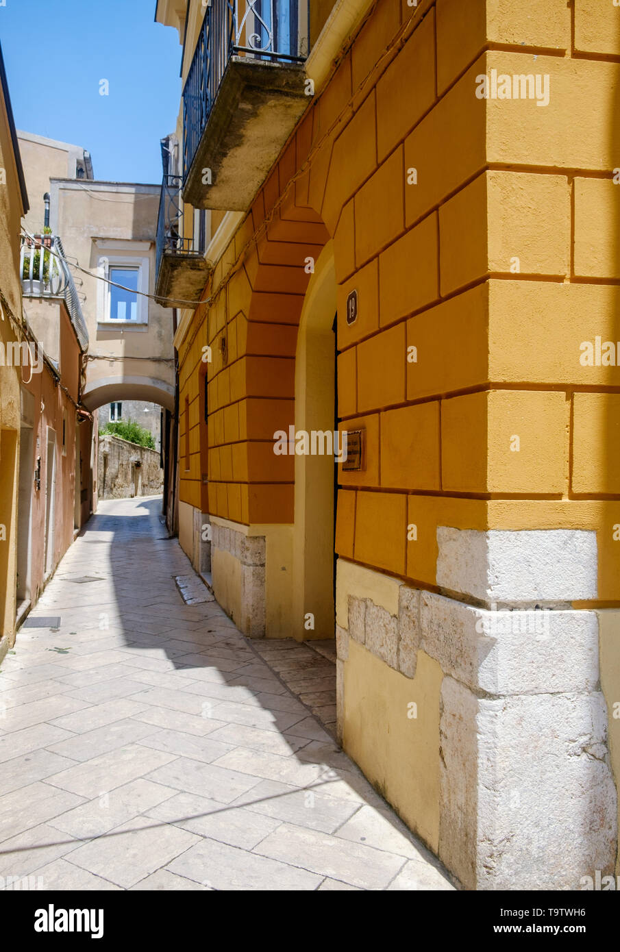 A strong orange facade lies alongside an alley in the historical center of Sant'Agata de' Goti, a stunning Italian village. Stock Photo