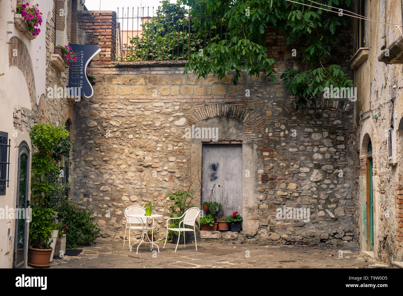 A small square in the middle of Benevento invites to sit down and enjoy a peaceful moment. A sign says 'Bed & Breakfast Le Streghe ('the witches'). Stock Photo