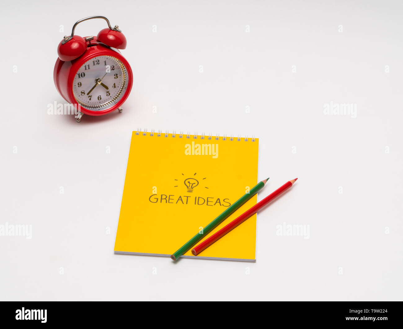 alarm clock with notepad and colored pencils on white background, isolated. back to school. great ideas Stock Photo