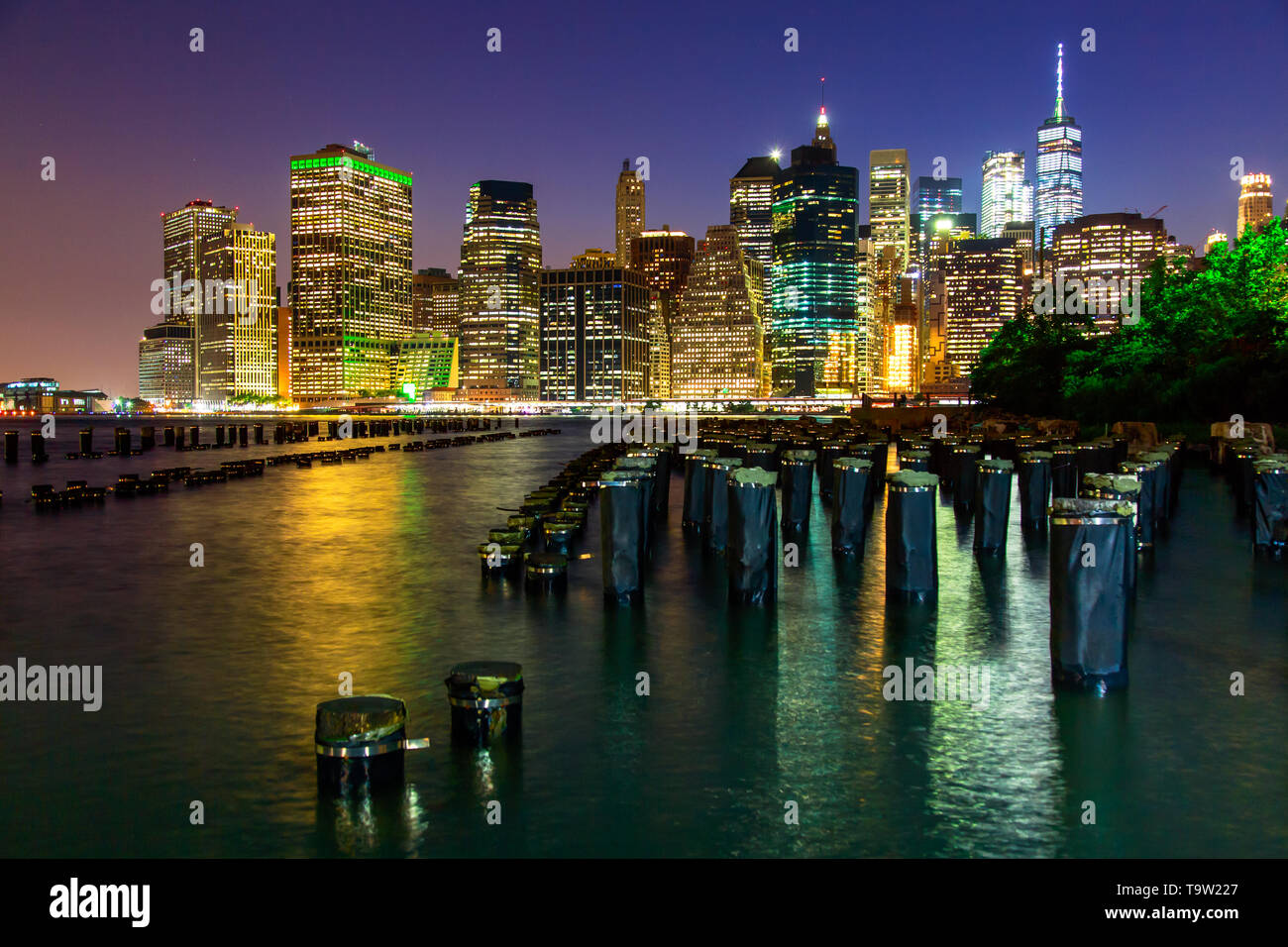 Manhattan at dusk viewed from the Brooklyn Bridge Park in New York City ...
