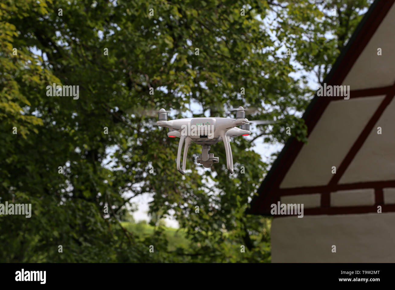Flying quadcopter with digital camera on blurred background. Stock Photo