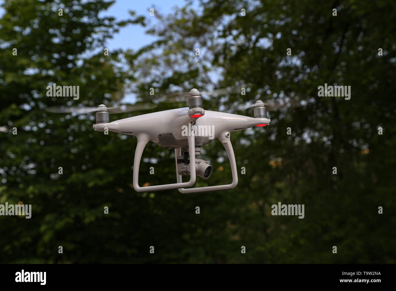 Flying quadcopter with digital camera on blurred background. Stock Photo