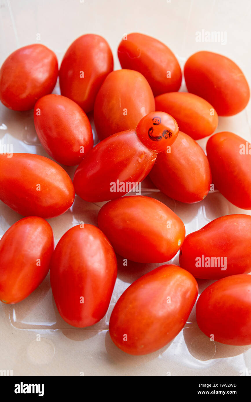 Odd Shaped Tomato In A Punnet Of Tomatoes With Added Drawn Face 