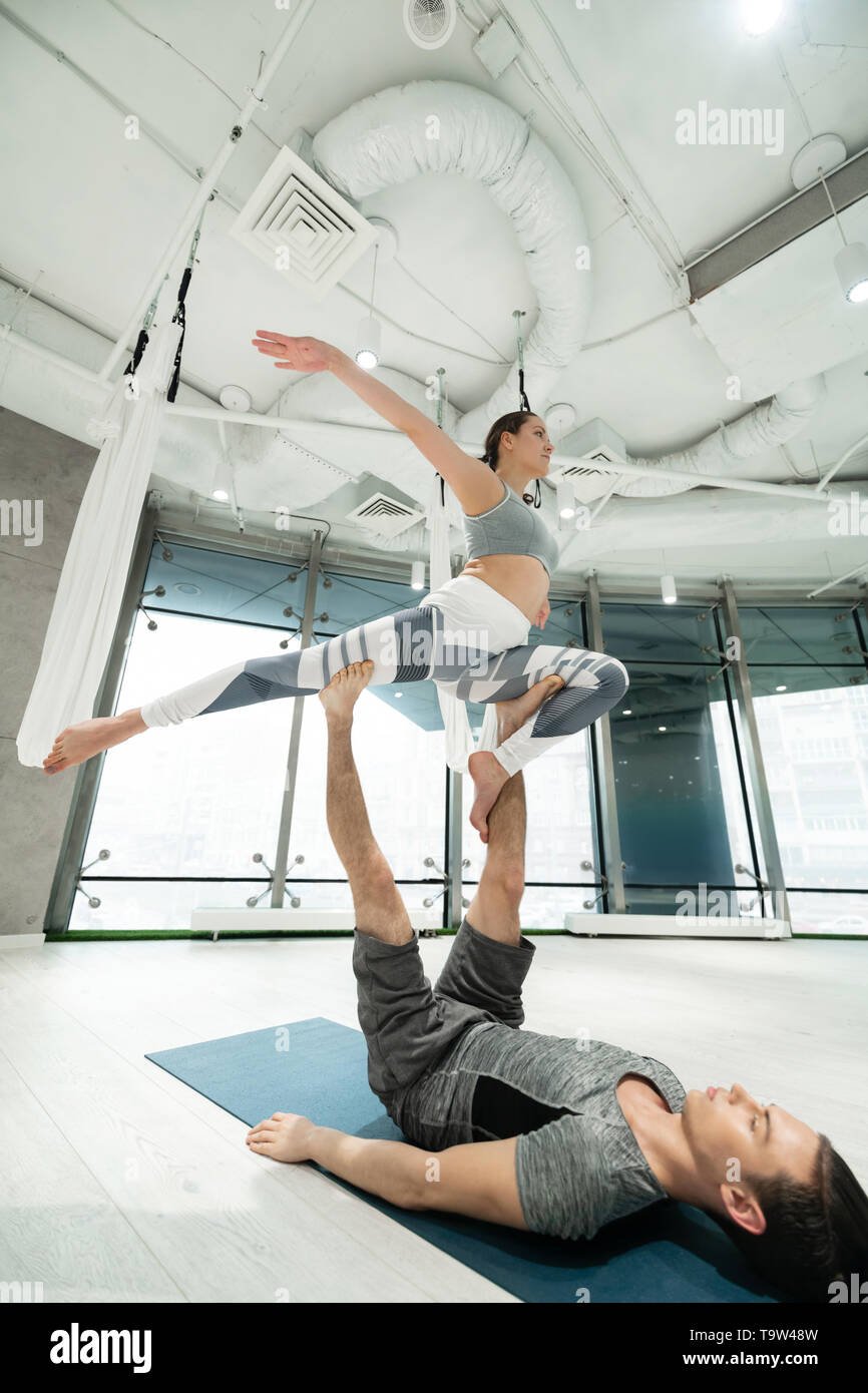 Strong sport couple practicing fitness yoga in spacious room Stock Photo