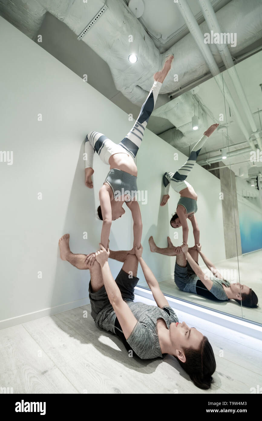 Professional yoga trainer practicing poses with husband Stock Photo Alamy