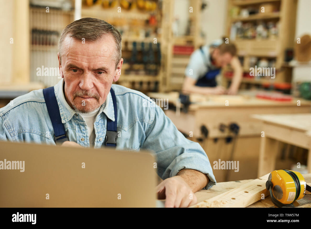 Senior craftsman using laptop hi-res stock photography and images - Alamy