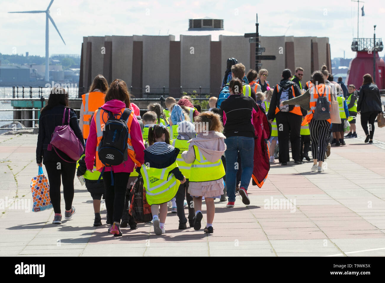 New Brighton, Wallasey. 21st May, 2019. UK Weather: Bright and sunny on the wirral riverside as pre-school children enjoy an escorted walk on the seafront promenade. Each child wearing a hi-vis tabard printed 'Slow down for Bobby' Twenty's Plenty; The Bobby Colleran Trust is Road Safety Charity offering advice and guidance for Parents and Schools. Since Bobby’s accident, his family have campaigned for safer roads outside all schools. Credit; MediaWorldImages/AlamyLiveNews. Stock Photo