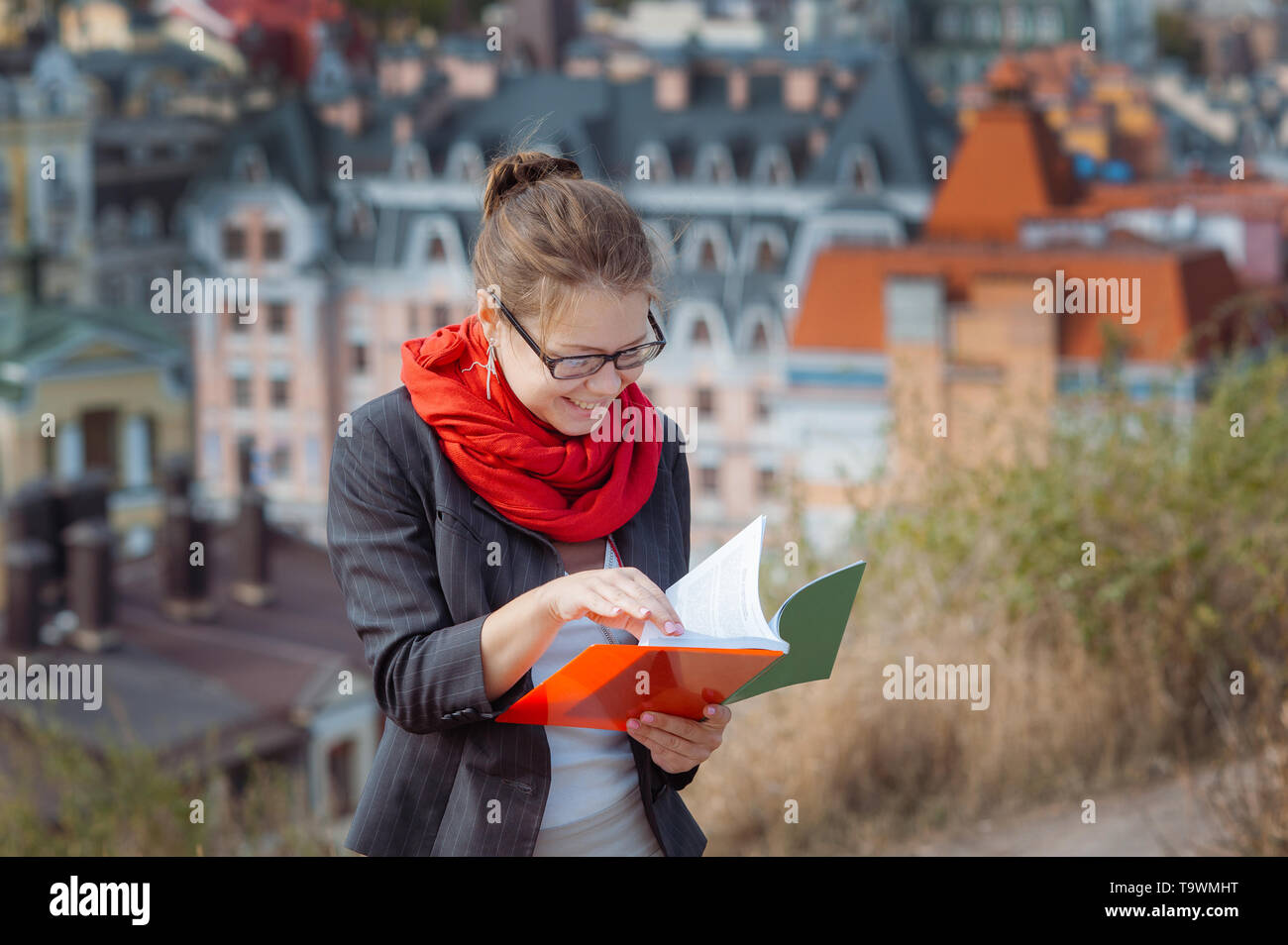 Portrait of happy smiling business woman with red folder in city Stock ...