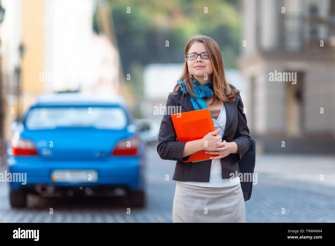 Portrait of happy smiling business woman with red folder in city Stock ...