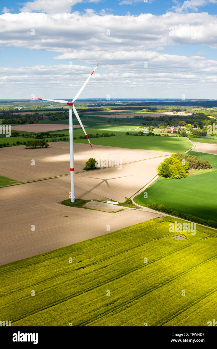 Wind turbine and its shadow in an agricultural landscape seen from eye level Stock Photo