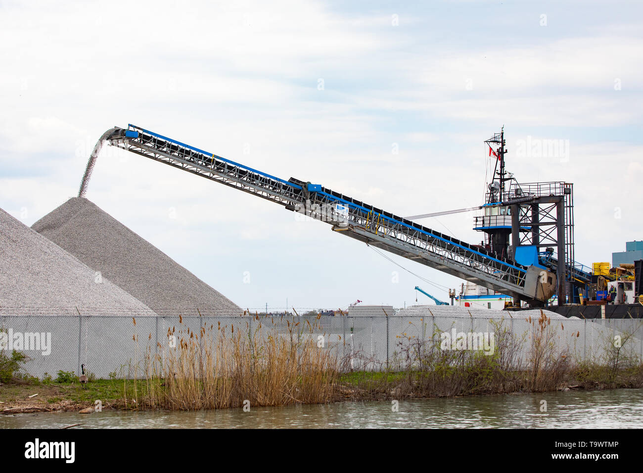 Industry International Domestic Shipping Telescopic Conveyor Belt Moving Rock Materials on a riverfront shipping route Stock Photo