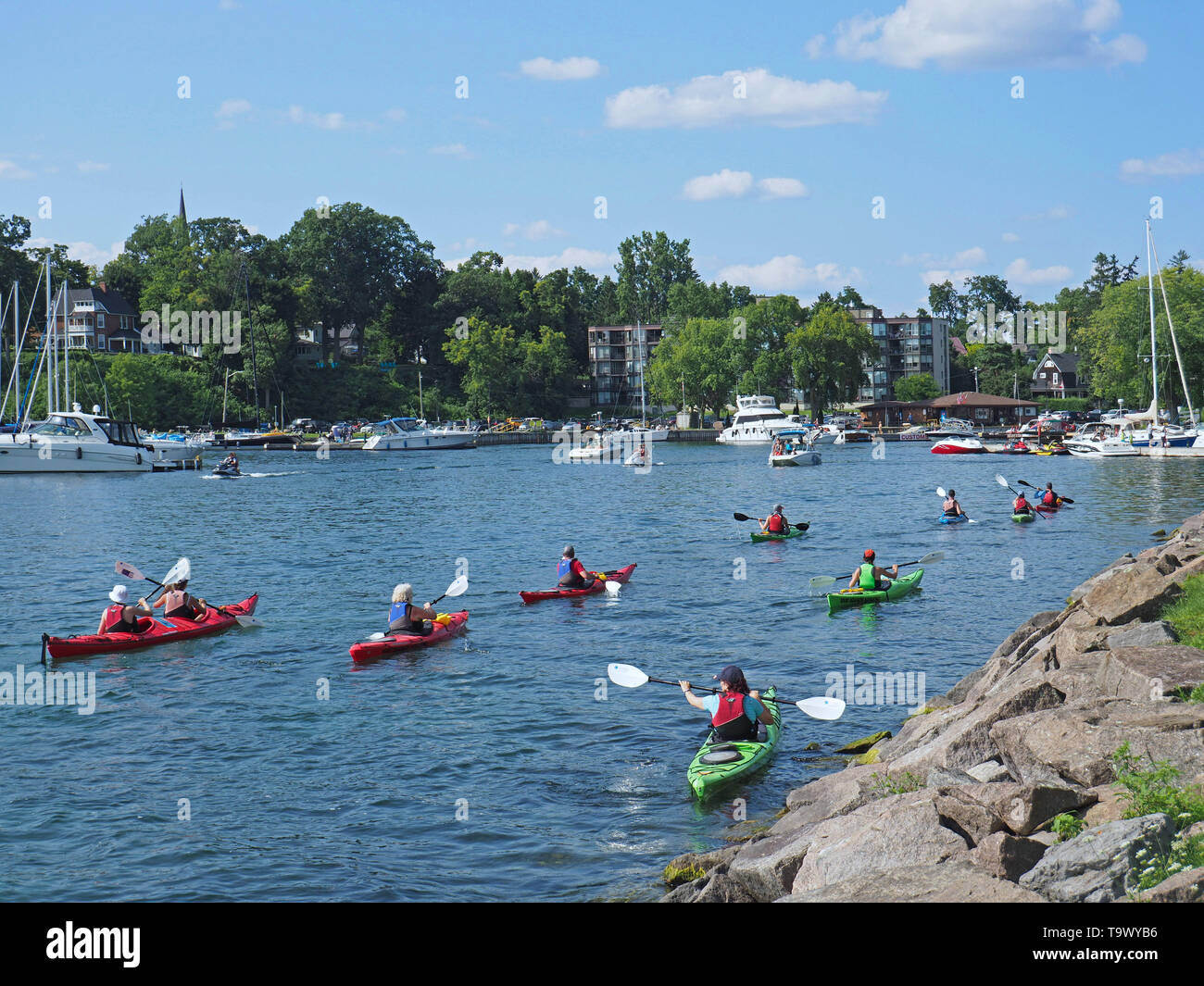 THOUSAND ISLANDS, CANADA - AUGUST 2018:  A group of kayakers on a paddle excursion among the Thousand Islands of the St. Lawrence River returns to Gan Stock Photo