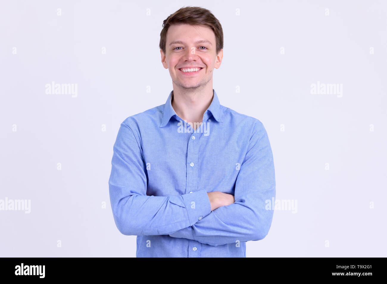 Portrait of young happy businessman smiling with arms crossed Stock ...