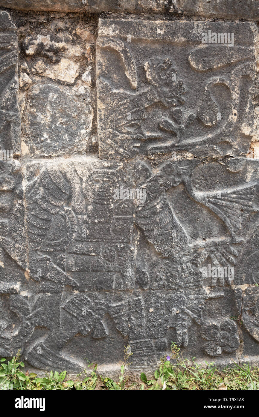 Mayan stone carving showing human sacrifice - a mayan carrying the head of a sacrificial victim (lower right); the ball court, Chichen Itza, Mexico Stock Photo