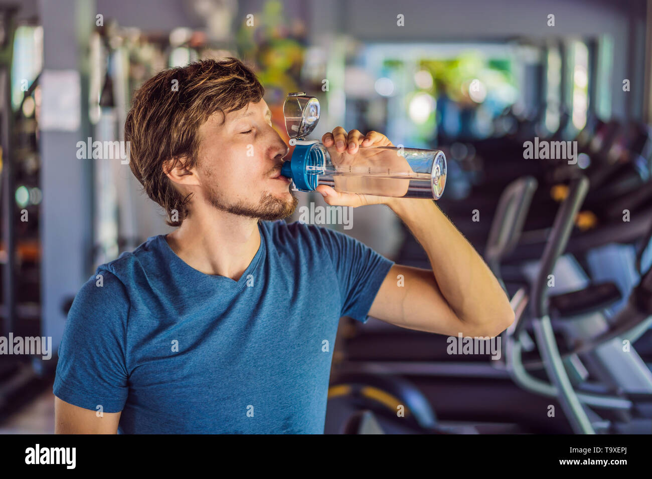 Sport man drinking water in the gym Stock Photo - Alamy