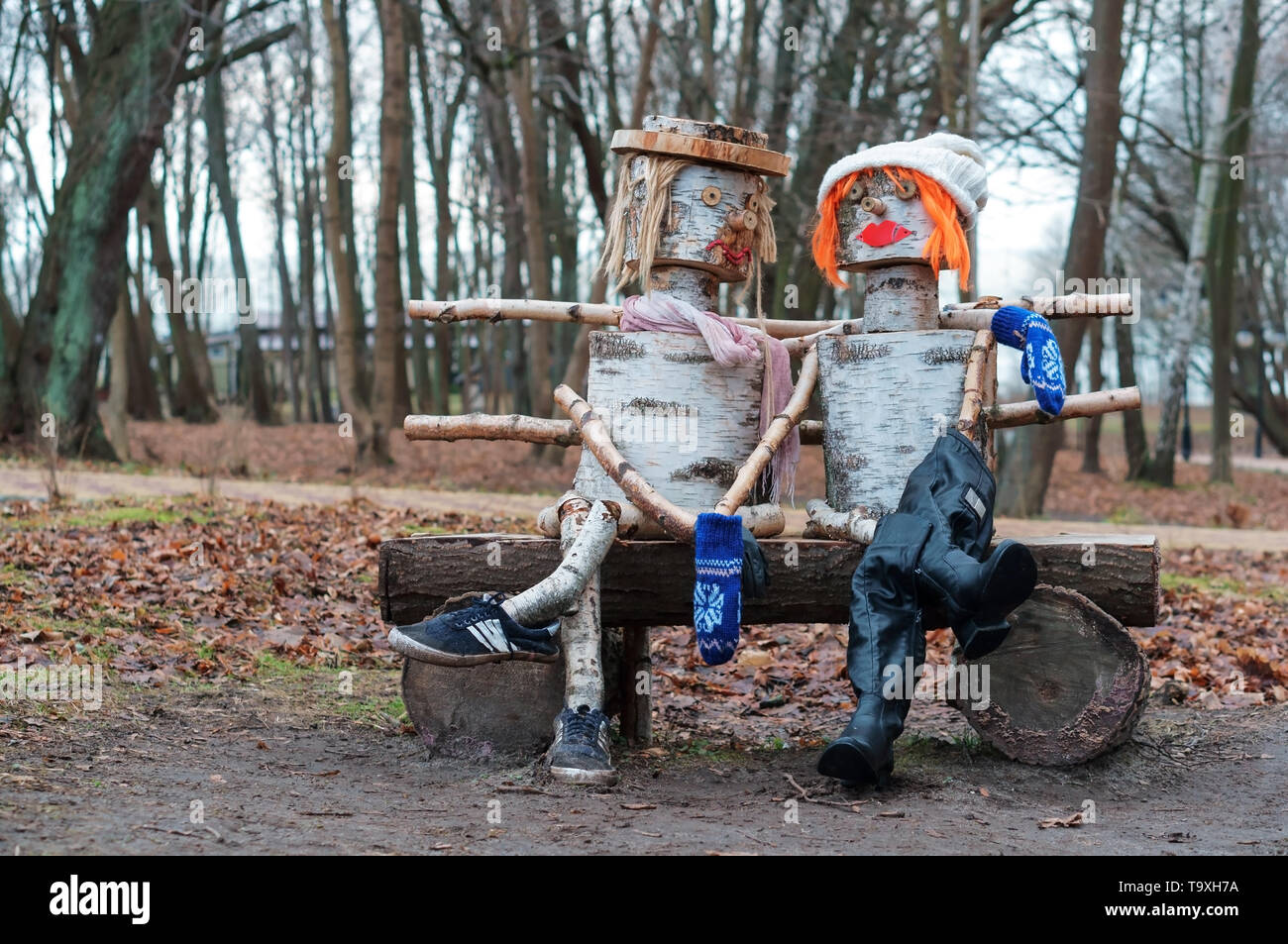 birch sculpture, man and woman on the bench wooden sculpture, Yantarny village, Kaliningrad region, Russia, January 20, 2019 Stock Photo