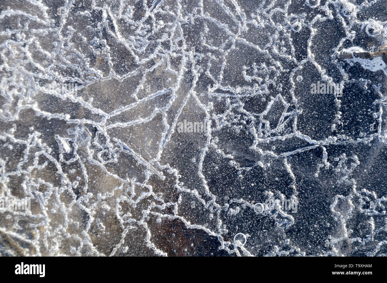 Texture abstract closeup background ice with grooves, furrows, and bubbles of air cought by frost in the mass of wated while freezing Stock Photo