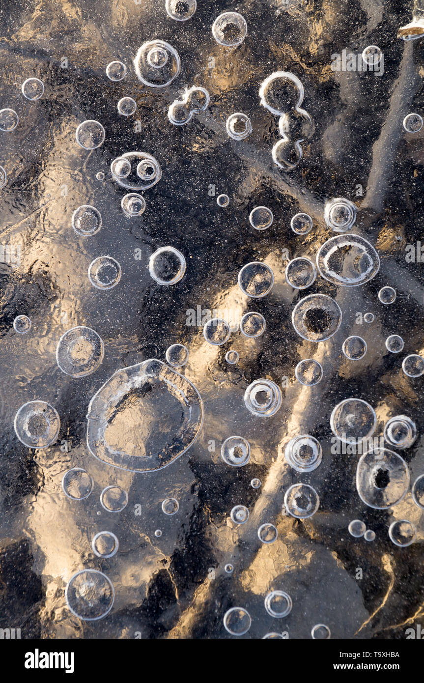 Texture abstract closeup background ice with grooves, furrows, and bubbles of air cought by frost in the mass of wated while freezing Stock Photo