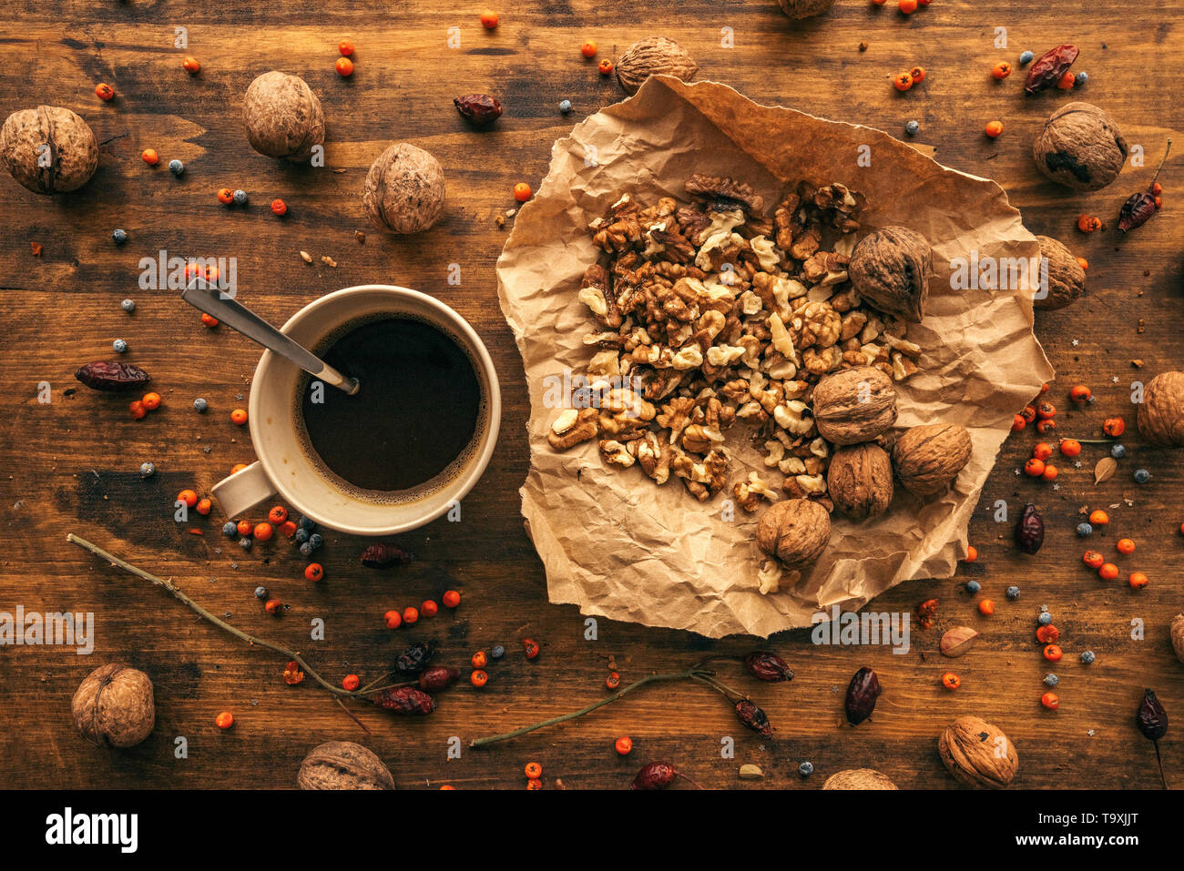 Ripe walnut fruit and coffee cup on table, top view of healthy antioxidant food Stock Photo