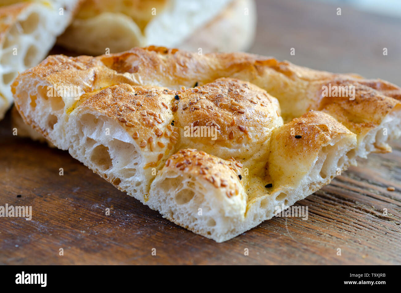 Slice of Ramadan Pita (Ramazan Pidesi) Traditional Turkish bread for holy month Ramadan on wooden background. Ramadan concept. Stock Photo