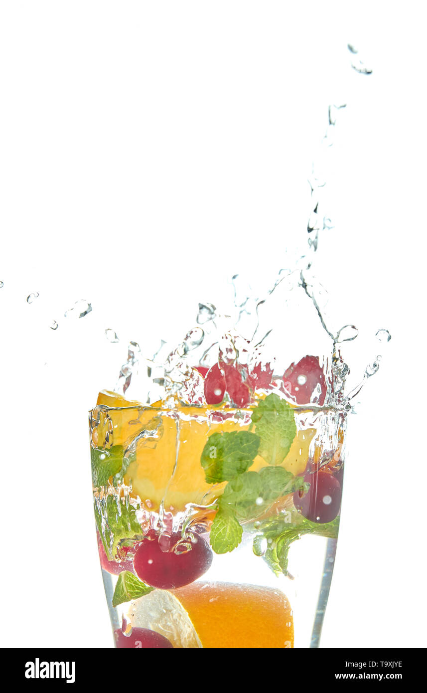 Detox lemonade with orange slices and berries with mint on a white background. refreshing drink