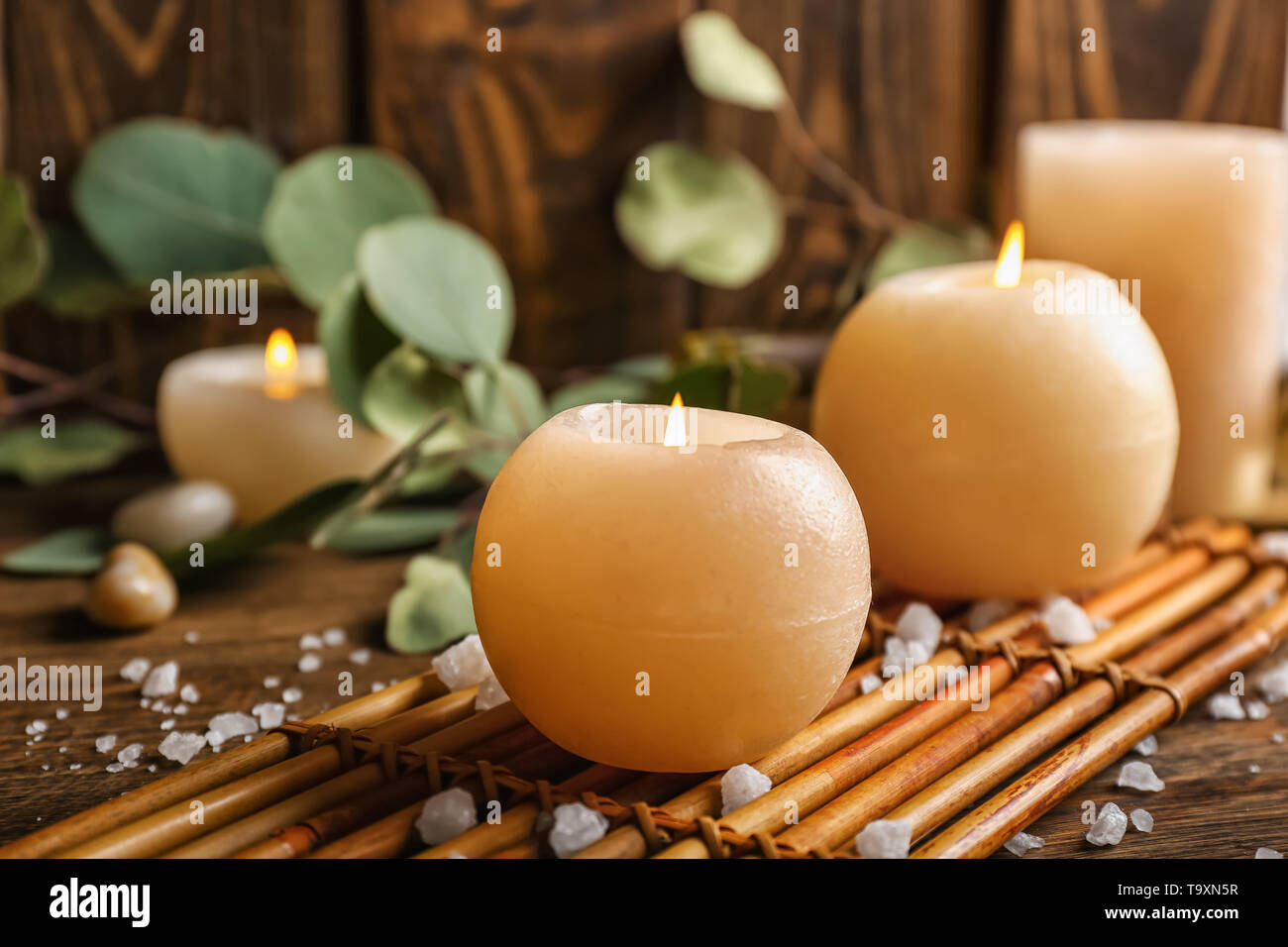 Beautiful burning candles on table in spa salon Stock Photo - Alamy