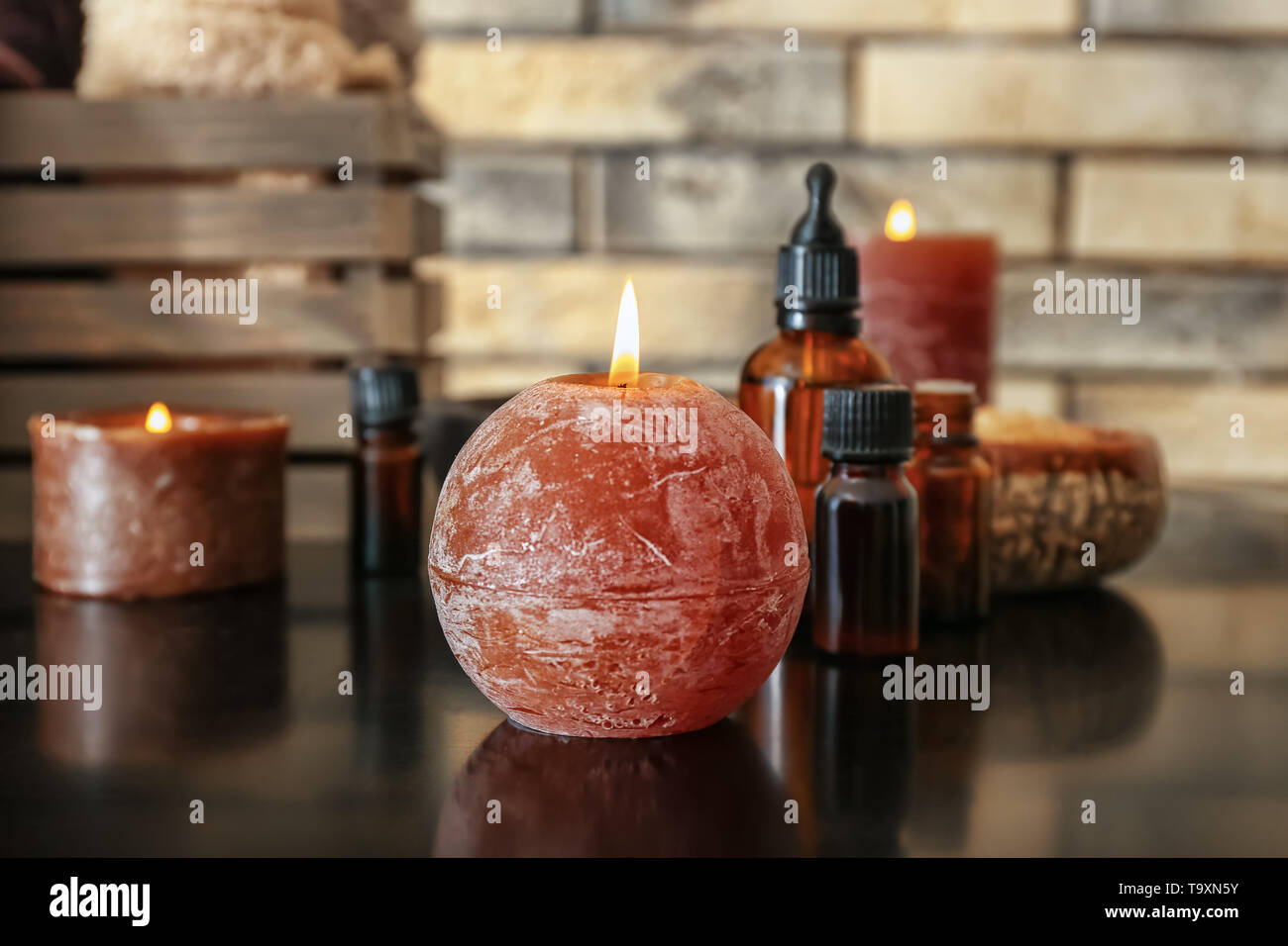 Burning candle on table in spa salon Stock Photo - Alamy