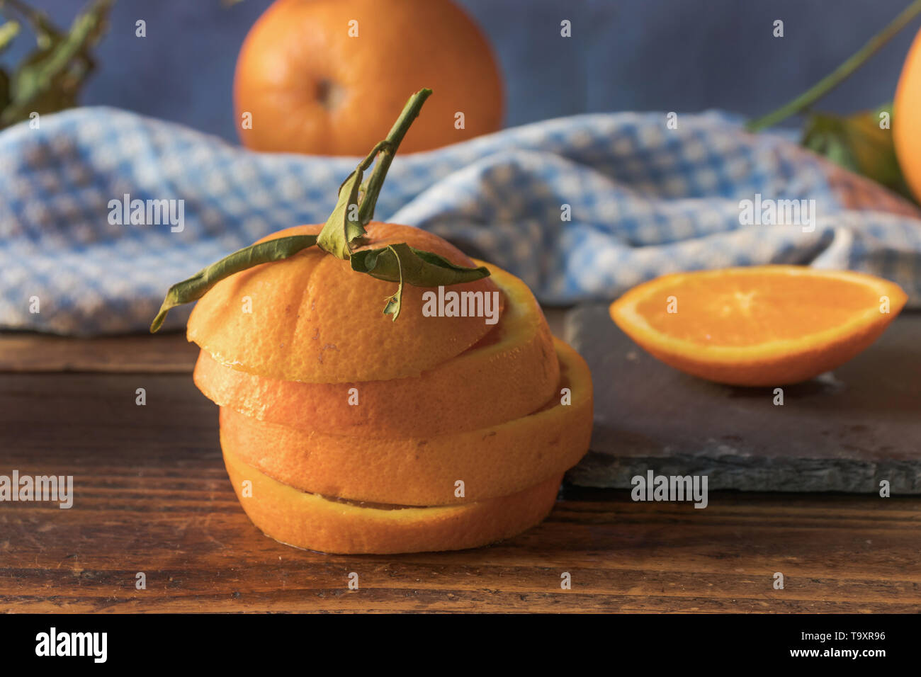 Fresh orange cut into slices on a wooden table. Front view Stock Photo