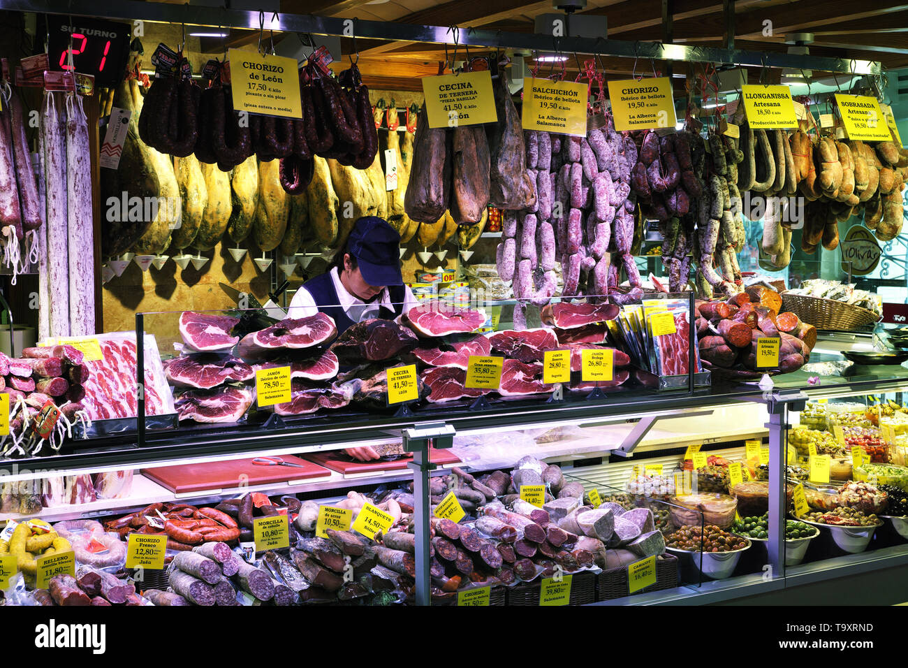 Palma Mallorca, Spain - March 20, 2019 : serrano and iberian iberico ham legs, sausage, chorizo and cheese on display for sale in the local farmers in Stock Photo