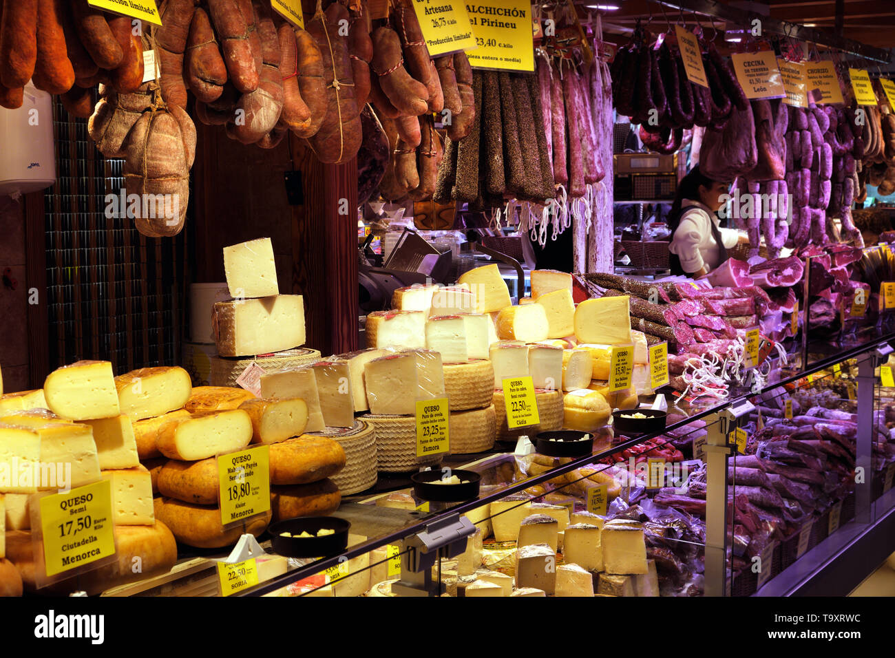 Palma Mallorca, Spain - March 20, 2019 : serrano and iberian iberico ham legs, sausage, chorizo and cheese on display for sale in the local farmers in Stock Photo