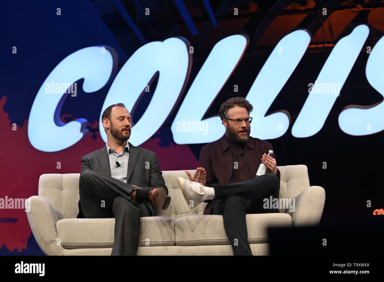 Collision 2019 - Opening Night Toronto , Canada - 20 May 2019; Seth Rogen, Co-founder, Houseplanton, centre, waves to the crowd with Evan Goldberg, Canadian screenwriter, and Karan Wadhera, Managing Partner, Casa Verde Capital, right, on centre stage during the opening night of Collision 2019 at Enercare Center in Toronto, Canada. Stock Photo