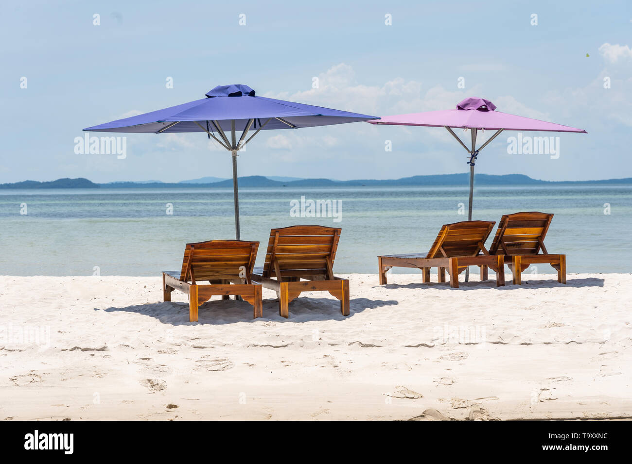 Lounge Chairs And Umbrella At The White Sand Beach Stock
