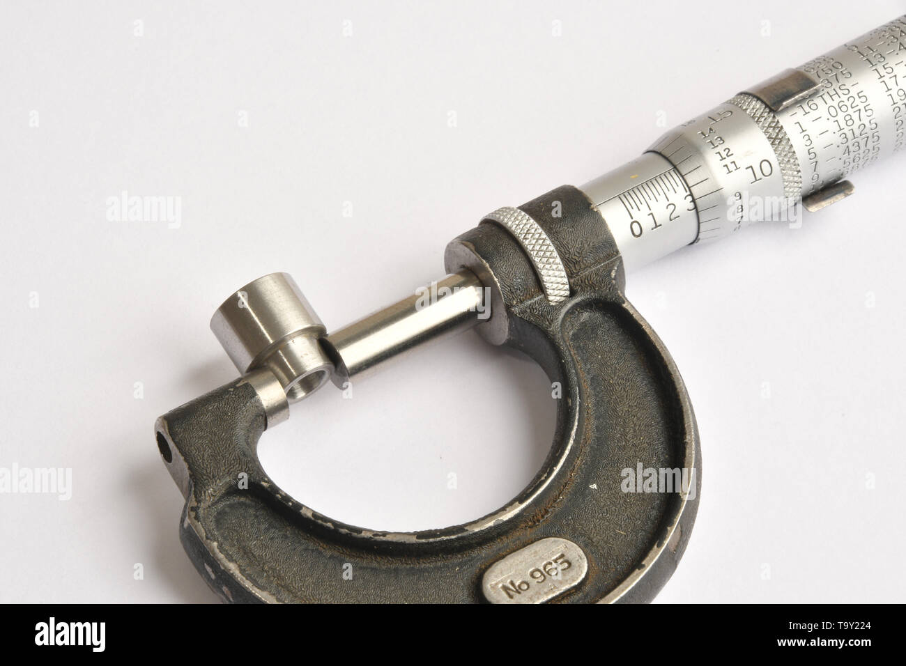 Manual micrometer 0-1.0'measuring the diameter of a turned steel component. Stock Photo