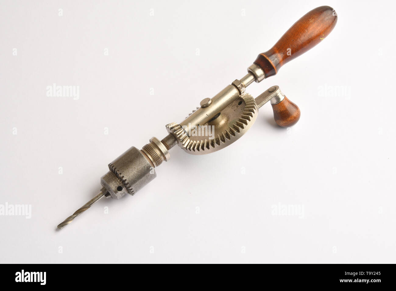 A hand operated geared drill fitted with a collet chuck holding a metal cutting drill bit. Stock Photo