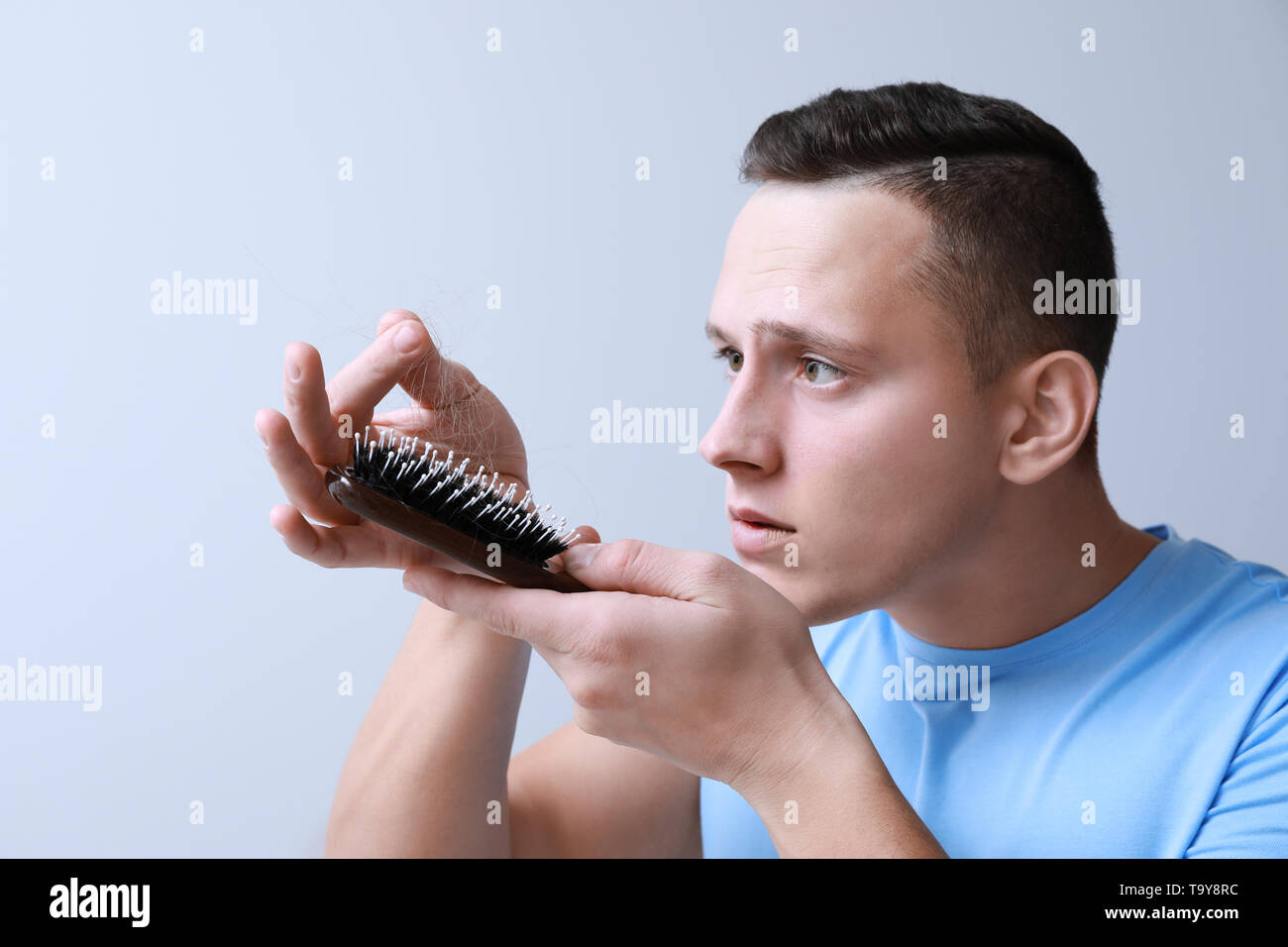 Man With Hair Loss Problem On Grey Background Stock Photo