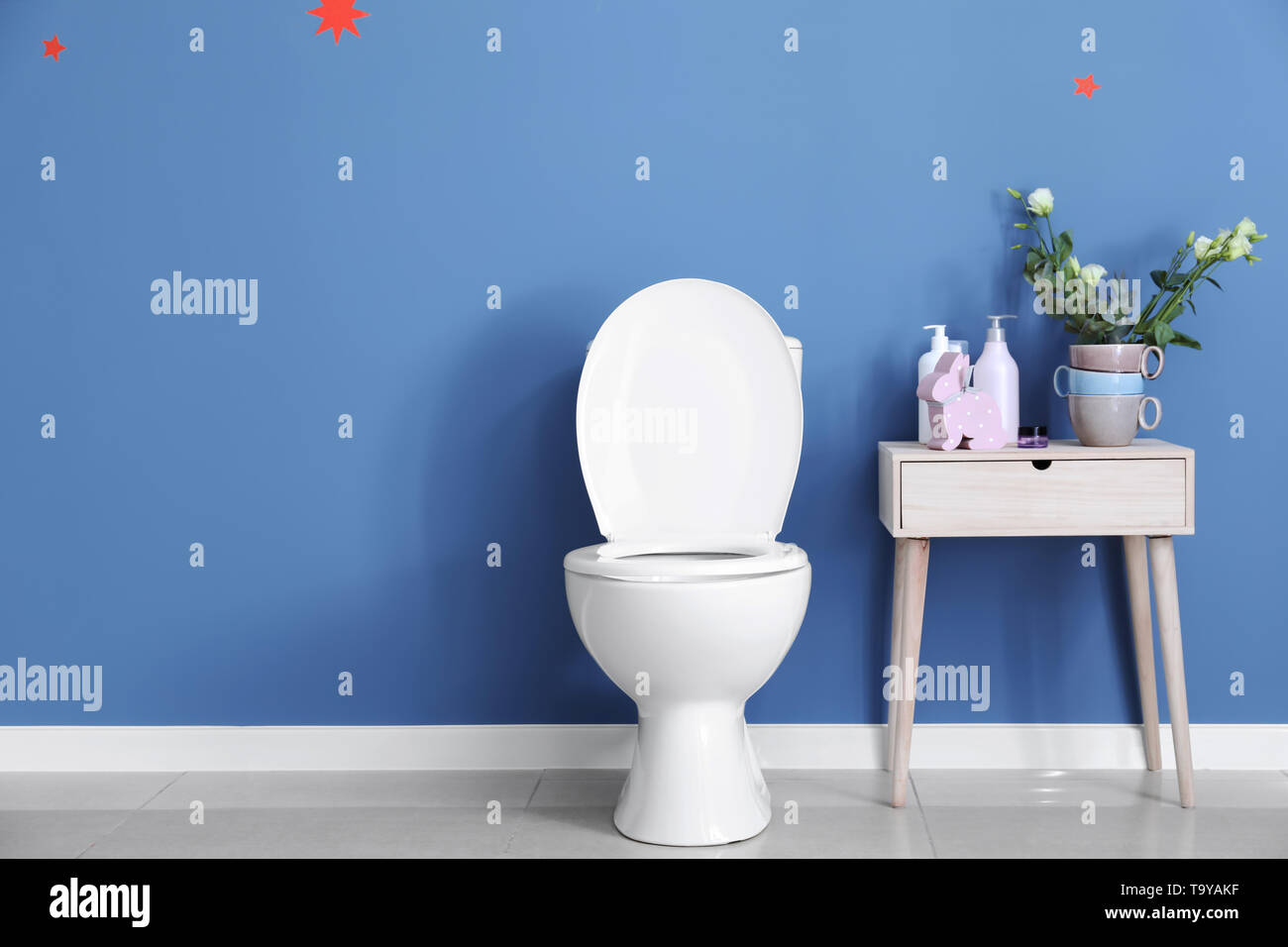 Modern ceramic toilet bowl near color wall in restroom Stock Photo Alamy