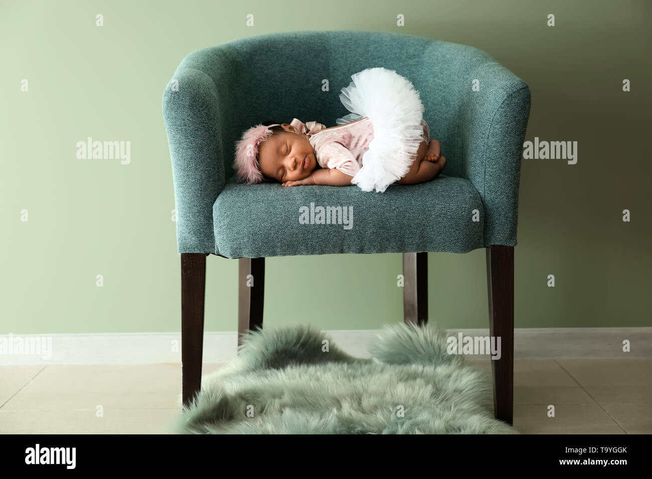 Cute AfricanAmerican baby sleeping in soft armchair indoors Stock