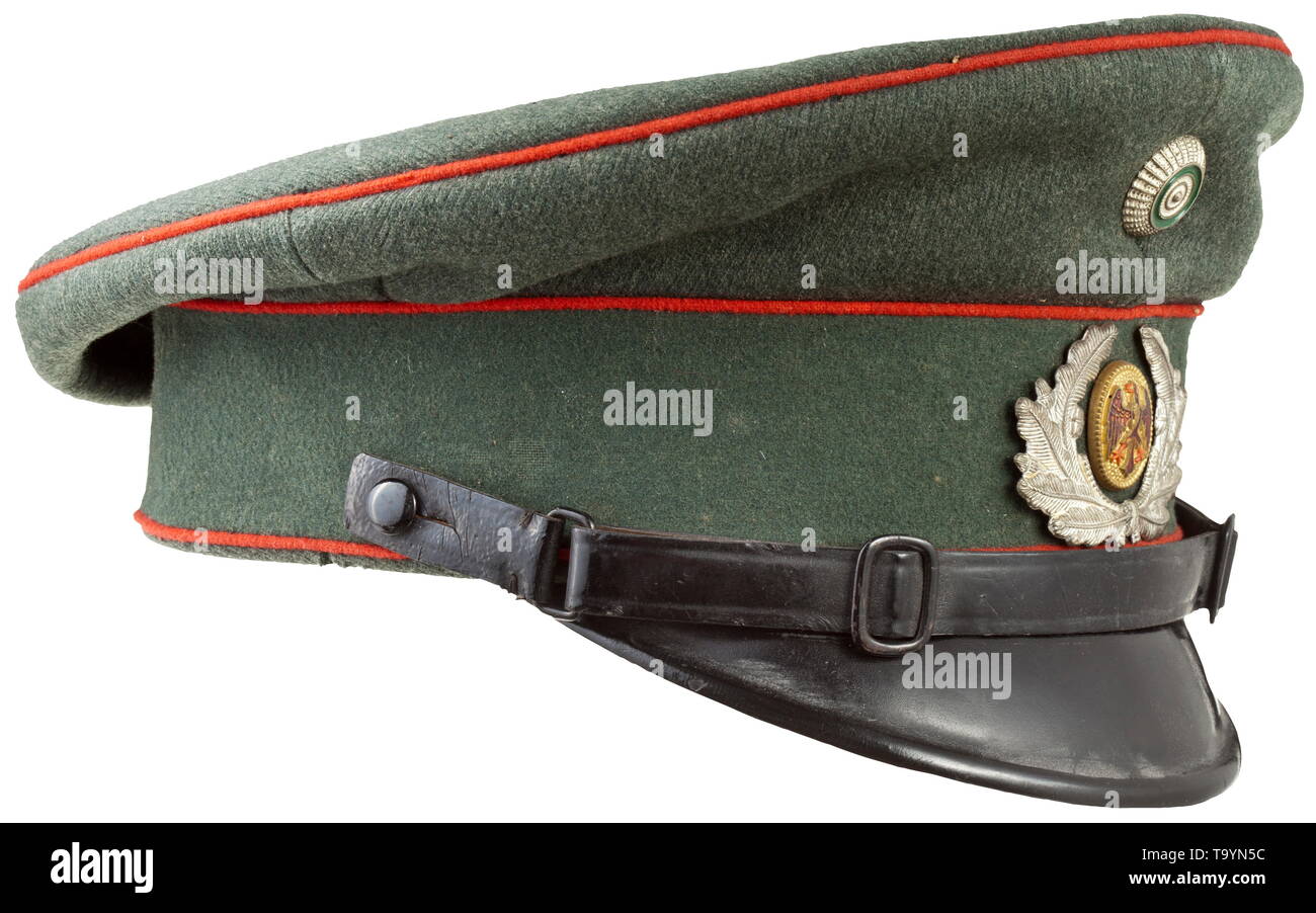 A Reichswehr visor cap for enlisted men/NCOs of the artillery Field-grey woollen cloth, green trim band, red piping, light brown inner liner, beneath the cap trapezoid the size designation '55', light brown leather sweatband, metal insignia, black patent leather straps. historic, historical, army, armies, armed forces, military, militaria, object, objects, stills, clipping, clippings, cut out, cut-out, cut-outs, 20th century, Editorial-Use-Only Stock Photo