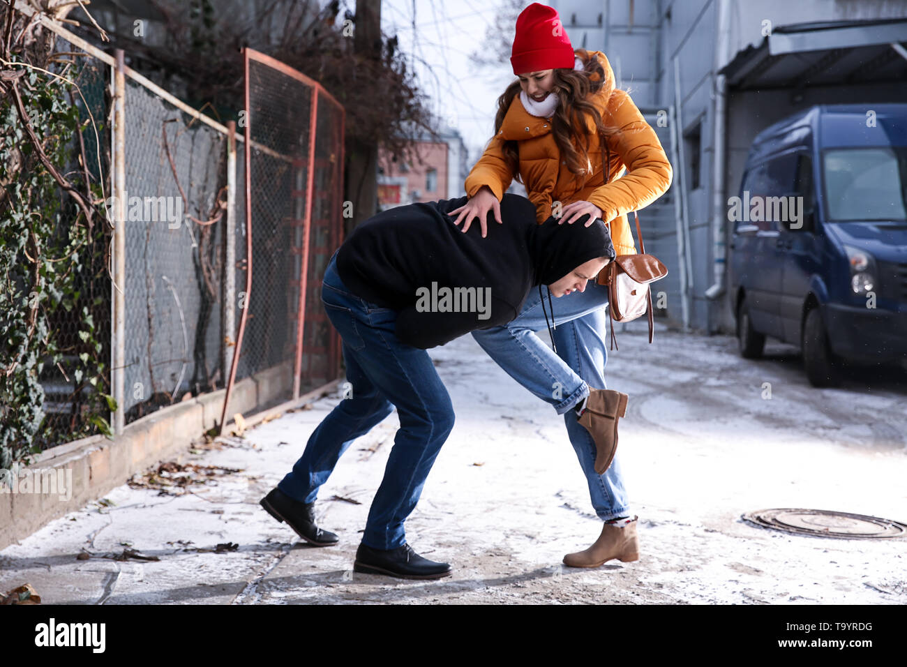 Young woman defending herself from thief outdoors Stock Photo
